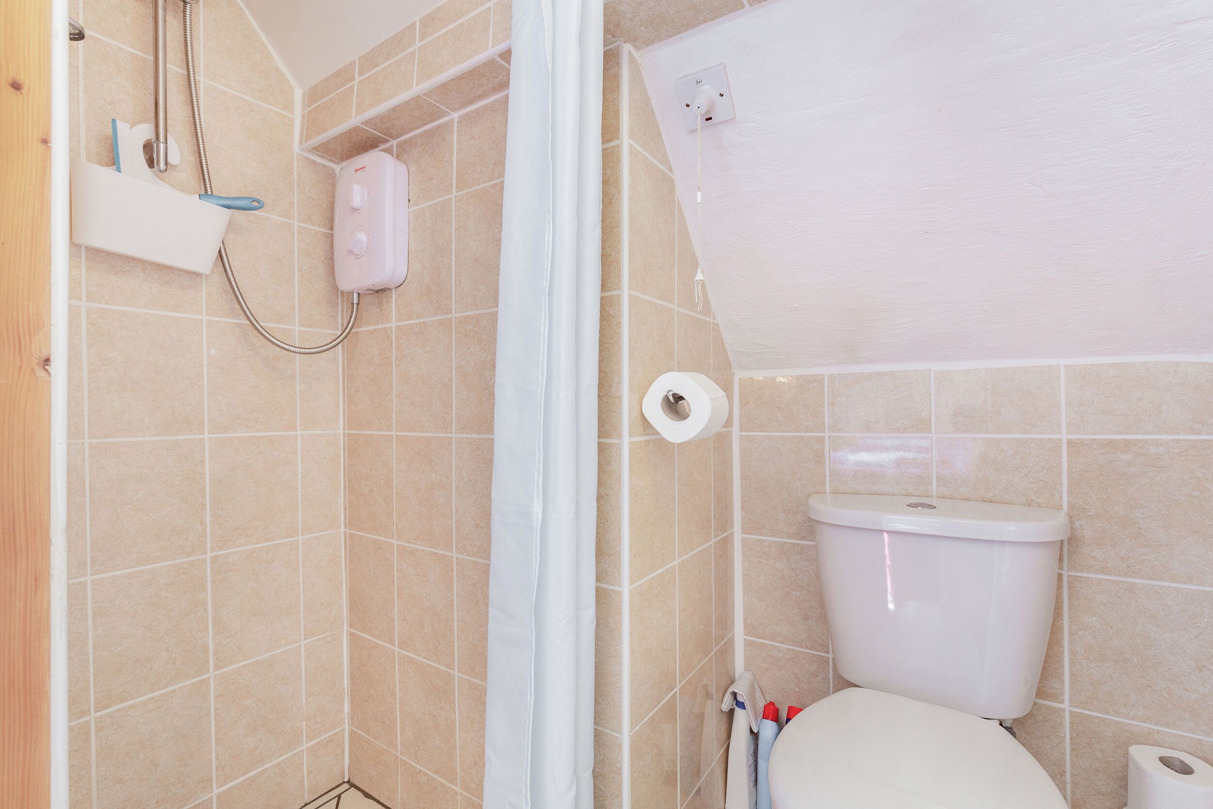 A bathroom with a shower, toilet, and a towel rack.