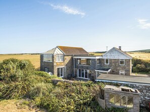 A two-story stone house with a large window on the upper floor and a smaller window on the ground floor. - Tregiffian Vean (Penzance)