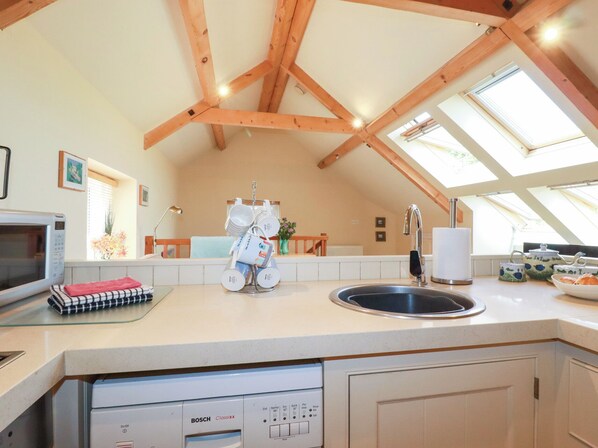 A kitchen with a dishwasher, sink, and a window with skylight. - Mithian Cottage (St. Agnes)