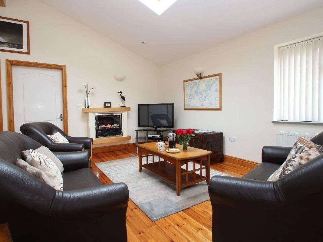 Ein Wohnzimmer mit Kamin, Fernseher und Couchtisch.