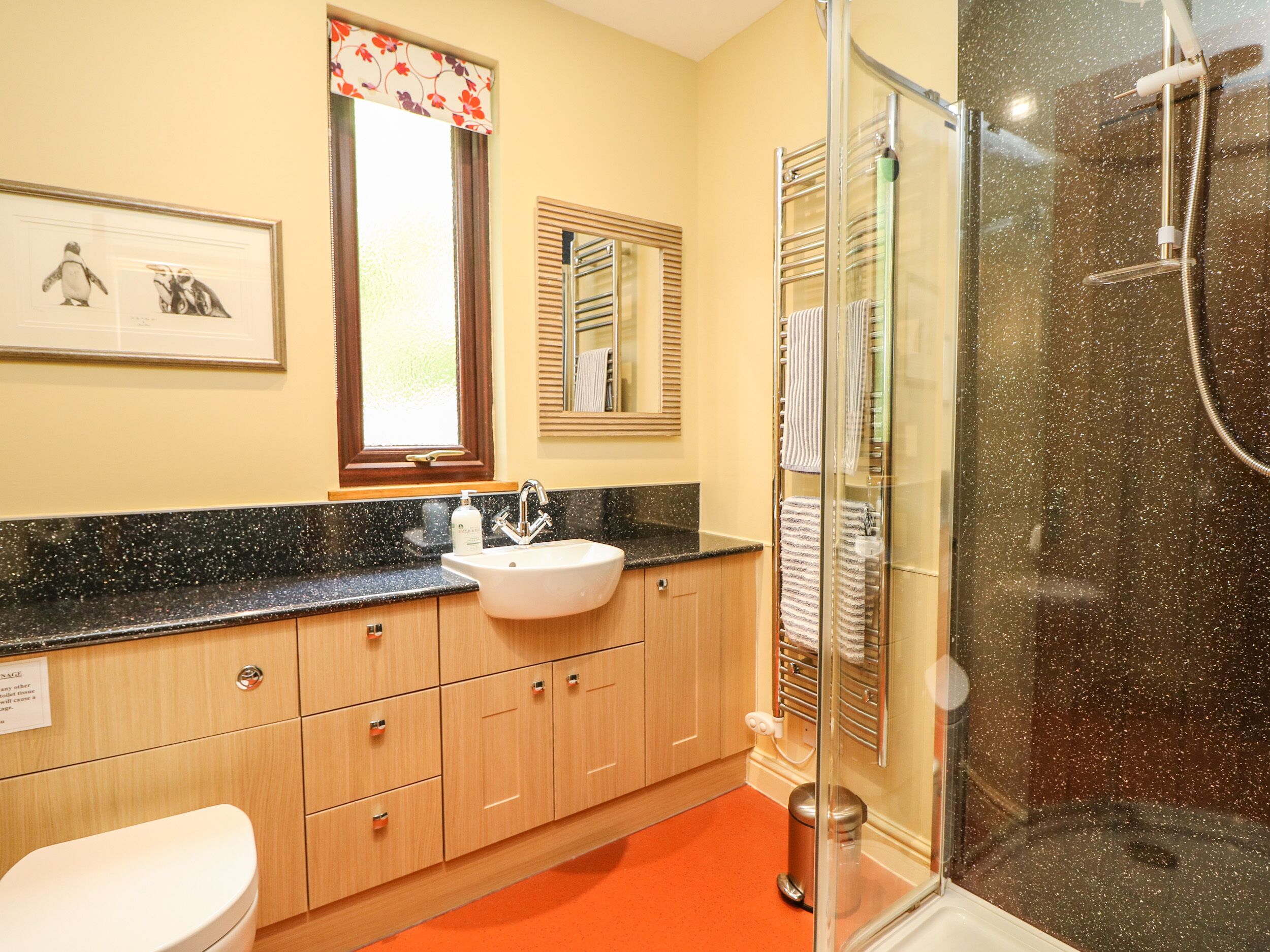 A bathroom with a sink, mirror, and shower.