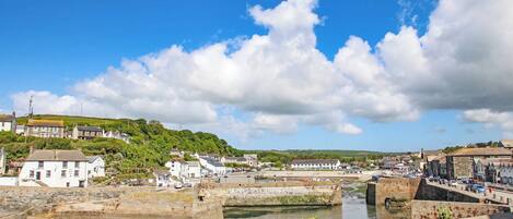 A coastal town with stone walls, buildings, and a clear sky.