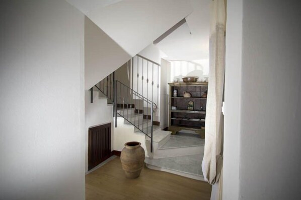A modern interior with a staircase, a wooden floor, and a rustic vase. - La Casa di Greta (Camogli)