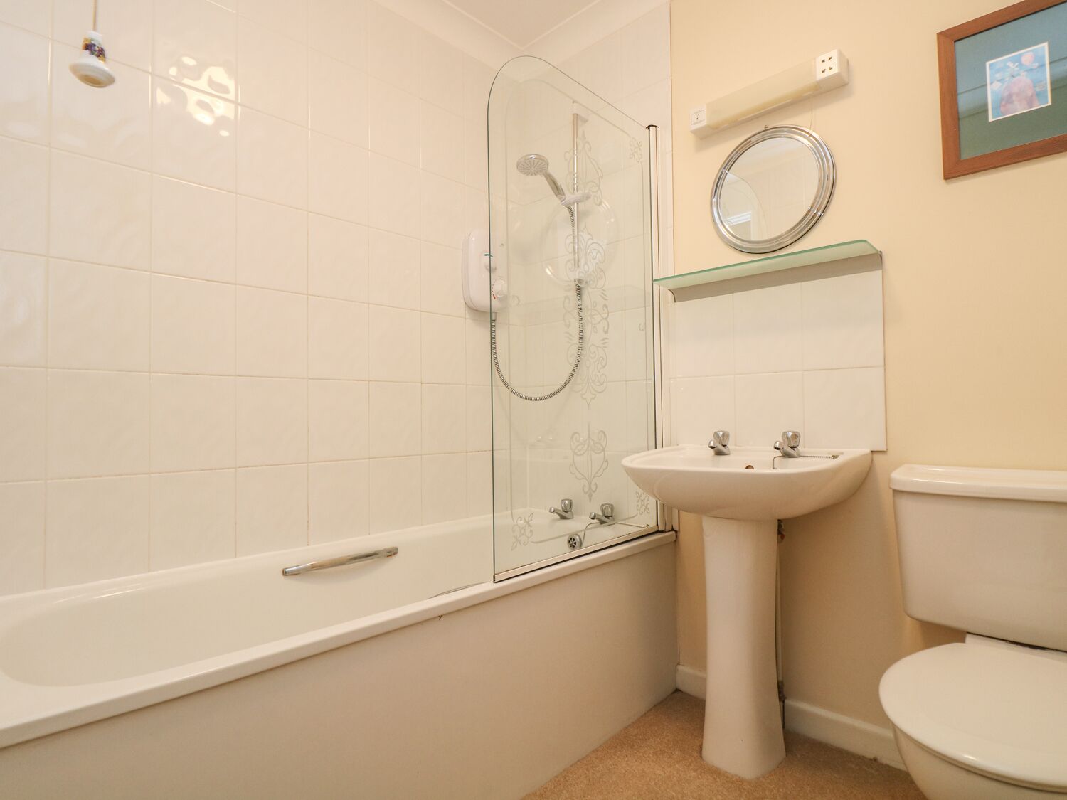 Ein Badezimmer mit Duschkabine, Waschtisch und Toilette.