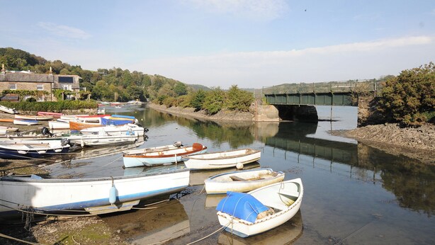 A river with several boats docked along the bank. - Byre (Lostwithiel)