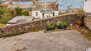 A coastal town with stone buildings, a harbor with boats, and a view of the sea. - Seabien (Falmouth)