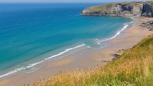 Un paisaje costero con playa, acantilados y cielo despejado.