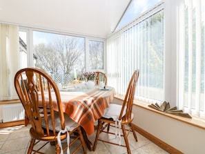 Enjoy meals in this cozy dining area with a table set for two, featuring a plaid tablecloth and comfortable chairs.