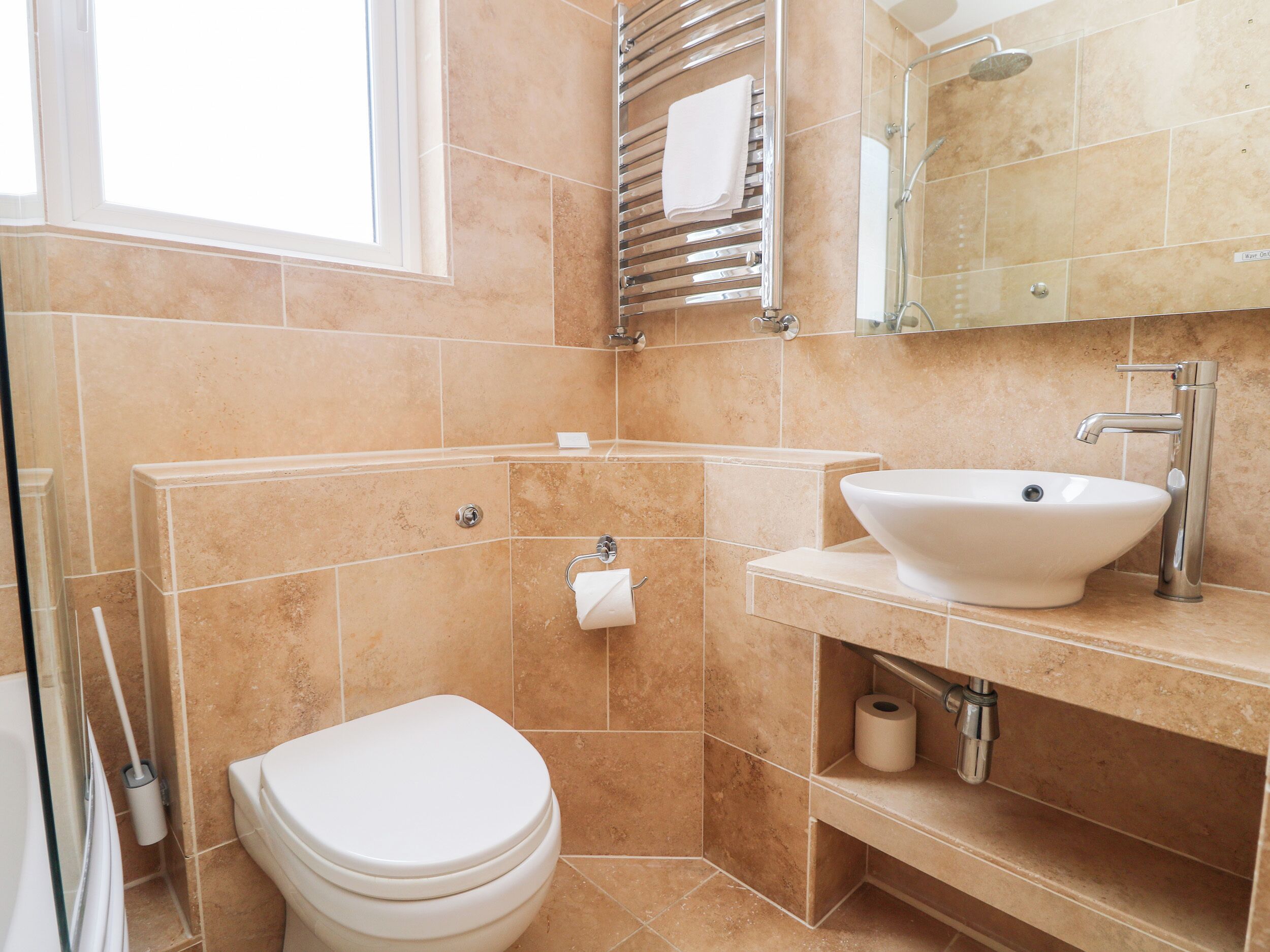 A bathroom with a toilet, sink, and shower.