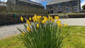 A stone building with a gravel driveway and a wooden fence. - Marhayes (Camelford)