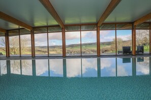 Una piscina interior con vistas despejadas del paisaje circundante a través de amplios ventanales.