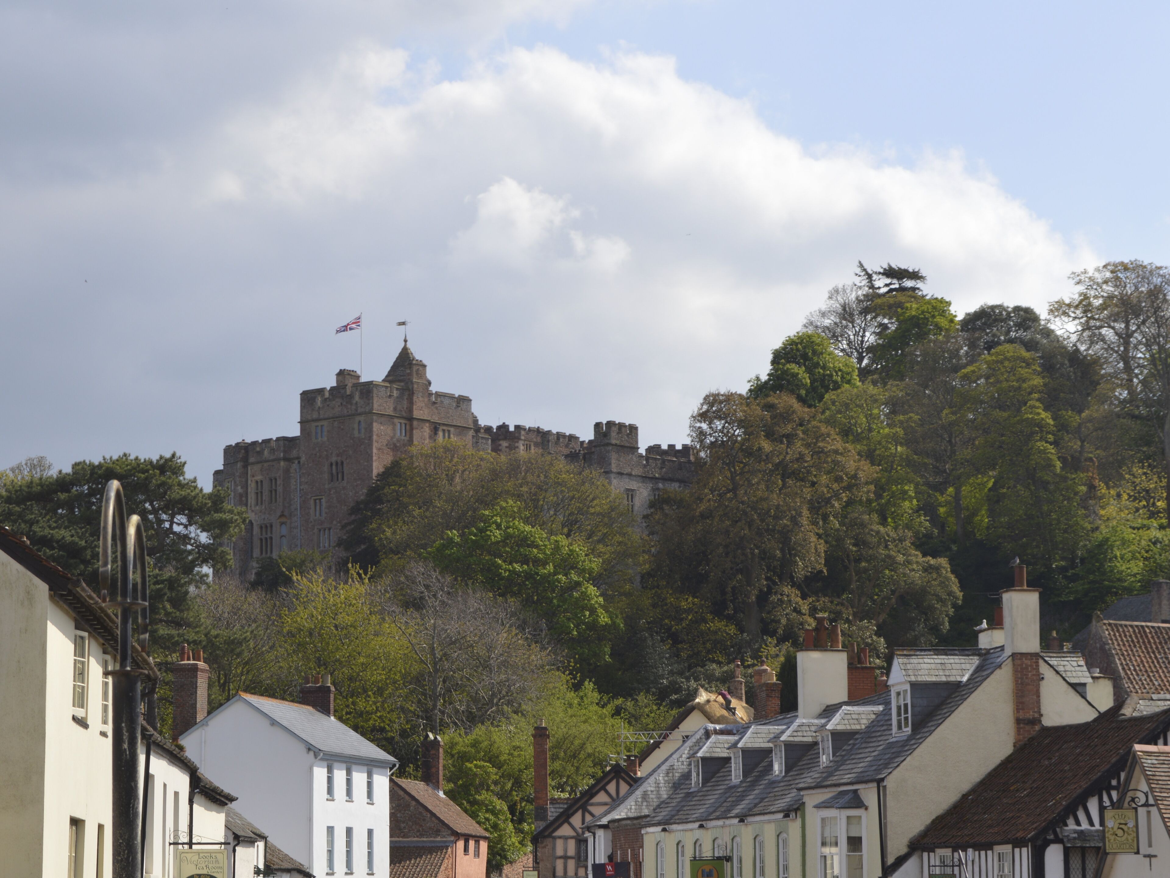 A historic castle on a hill with traditional buildings in the foreground.