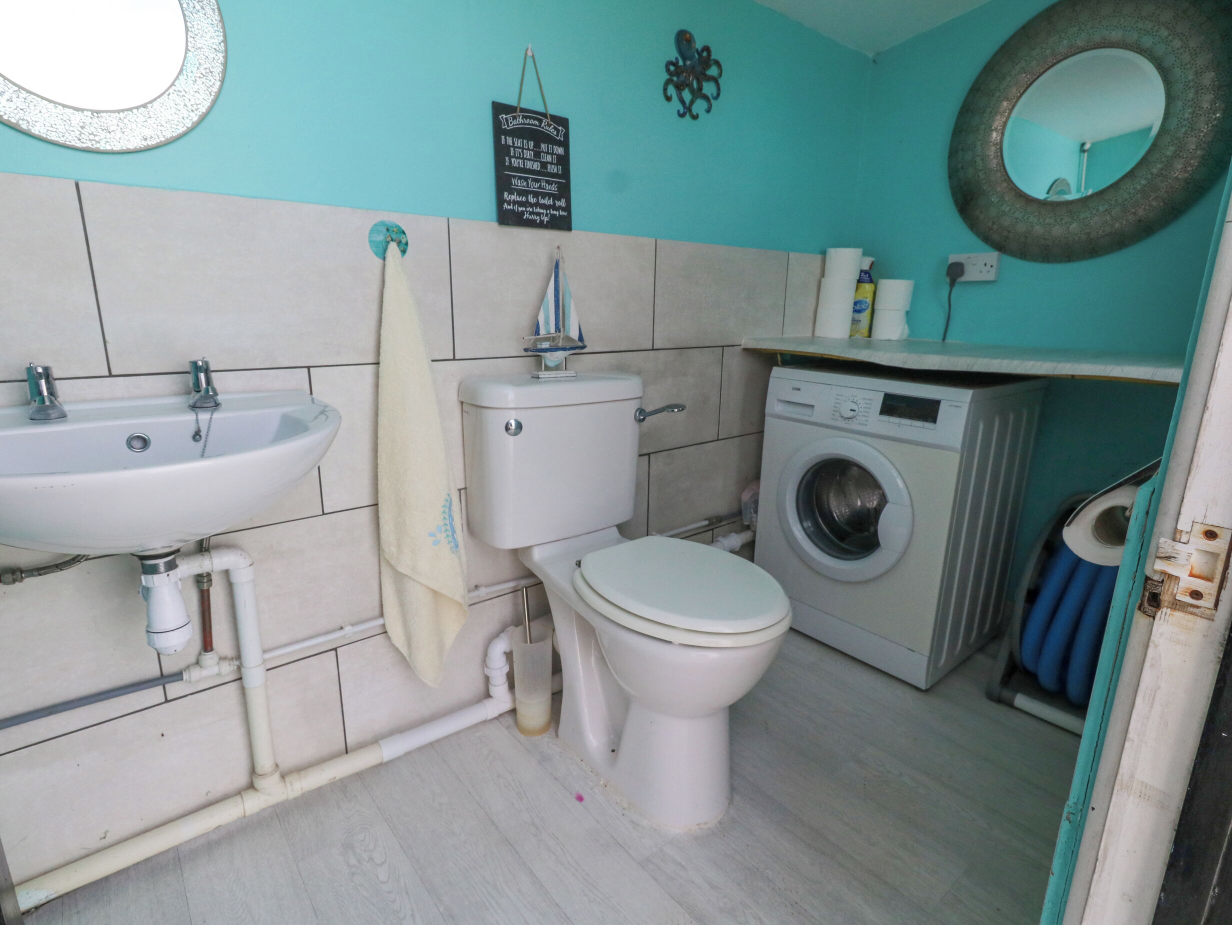 A bathroom with a sink, toilet, and washing machine.
