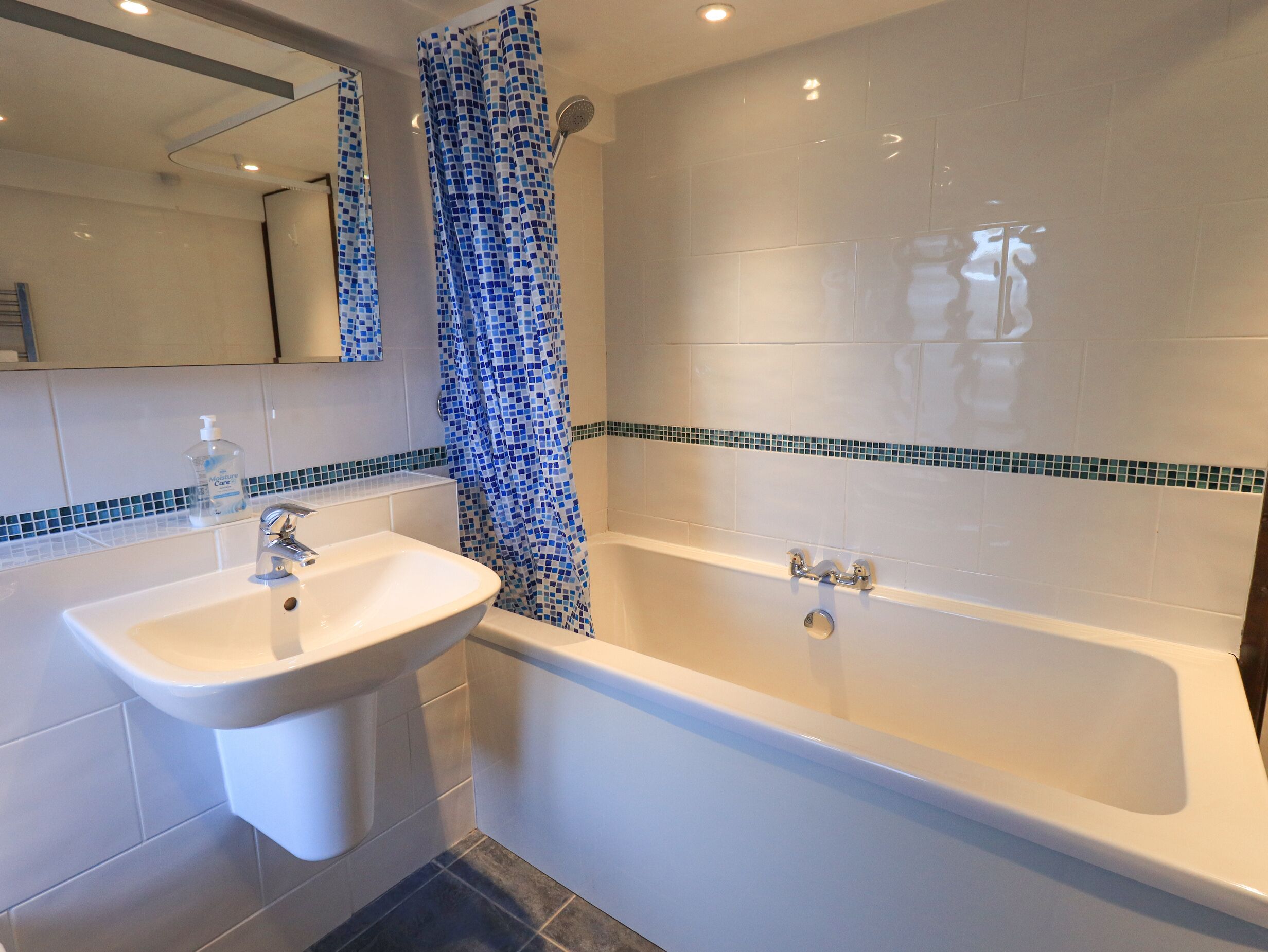 Une salle de bain équipée d’un lavabo, d’une baignoire et d’un rideau de douche.