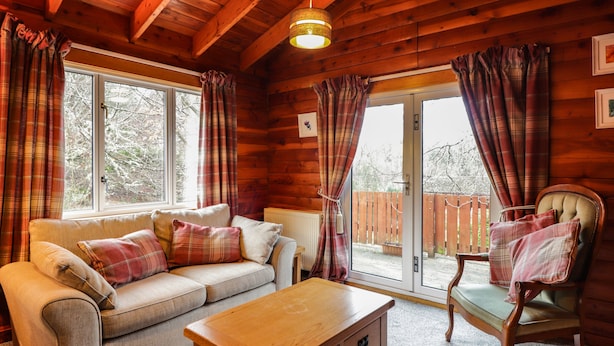 Un interno accogliente con un divano, un tavolo di legno e una poltrona.