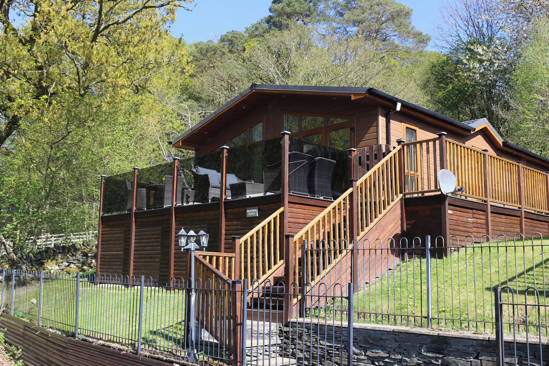A wooden cabin with a balcony and a staircase leading to the upper level.
