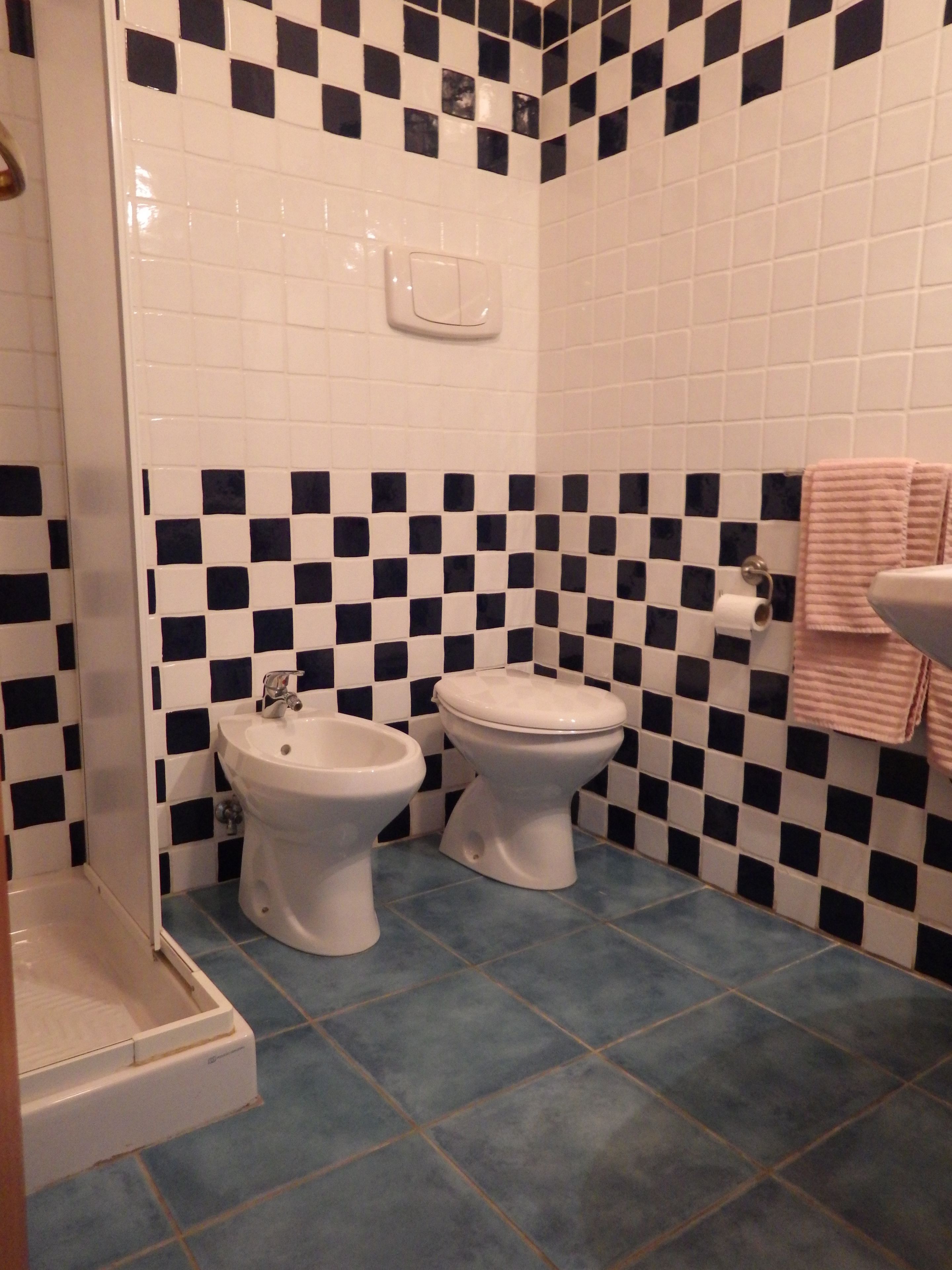 Une salle de bain avec deux toilettes, un bidet et un lavabo.
