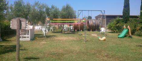 A playground with swings, slides, and a basketball hoop.