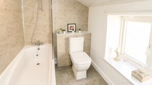 A bathroom with a bathtub, toilet, and shower. - Kings Cottage (Alston)