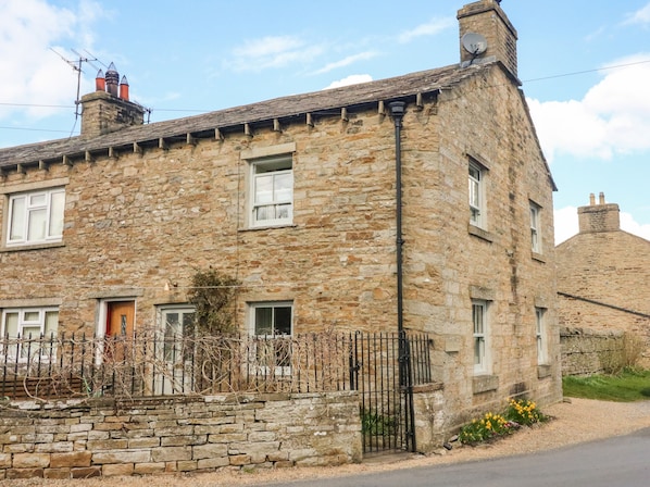 A stone building with multiple windows and a brick chimney. - Bill's Place (Leyburn)