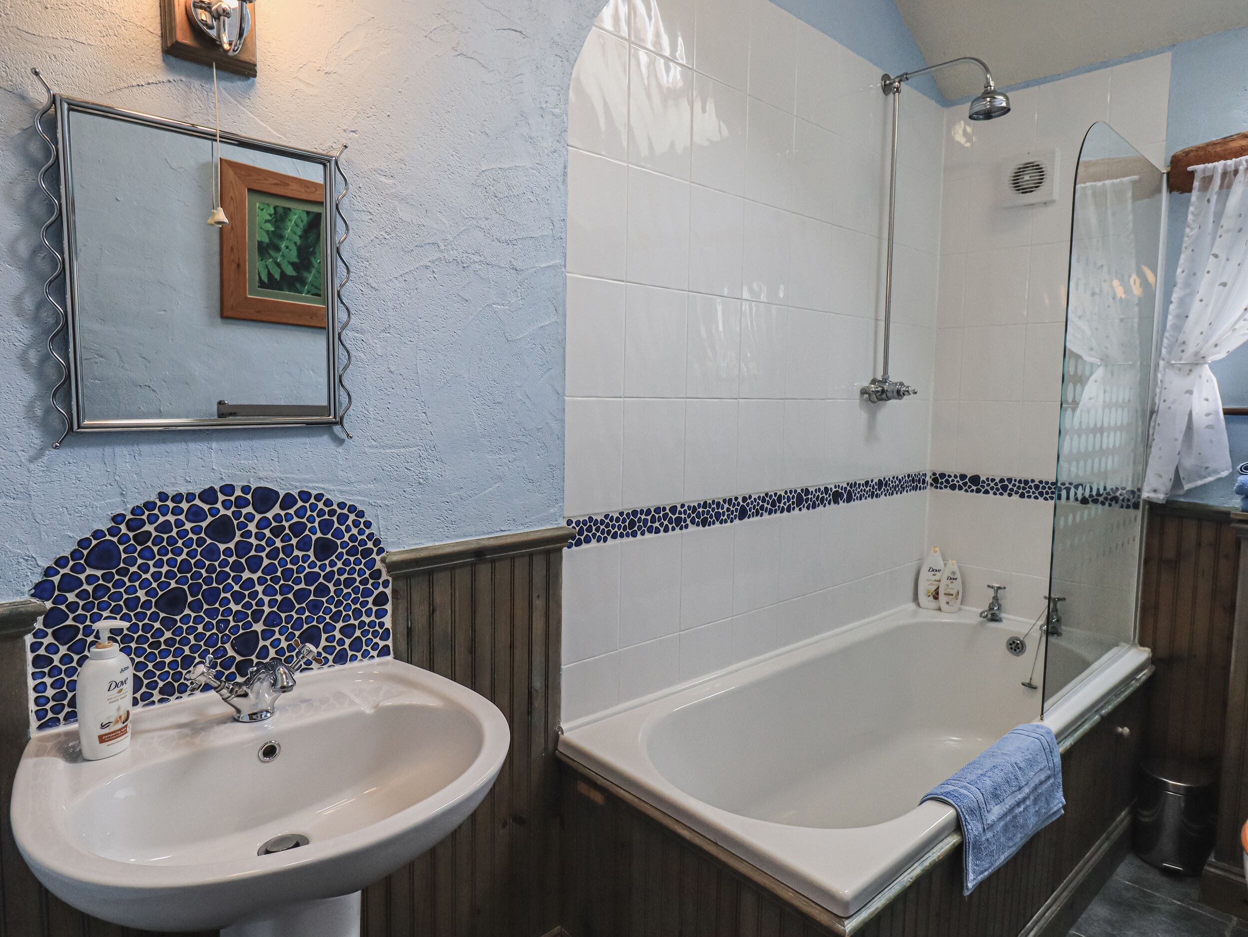 Un bagno con lavandino, specchio e vasca da bagno.