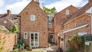 A brick house with a central door, a small garden, and a wooden fence. - Wards Court 2 (Gloucester)