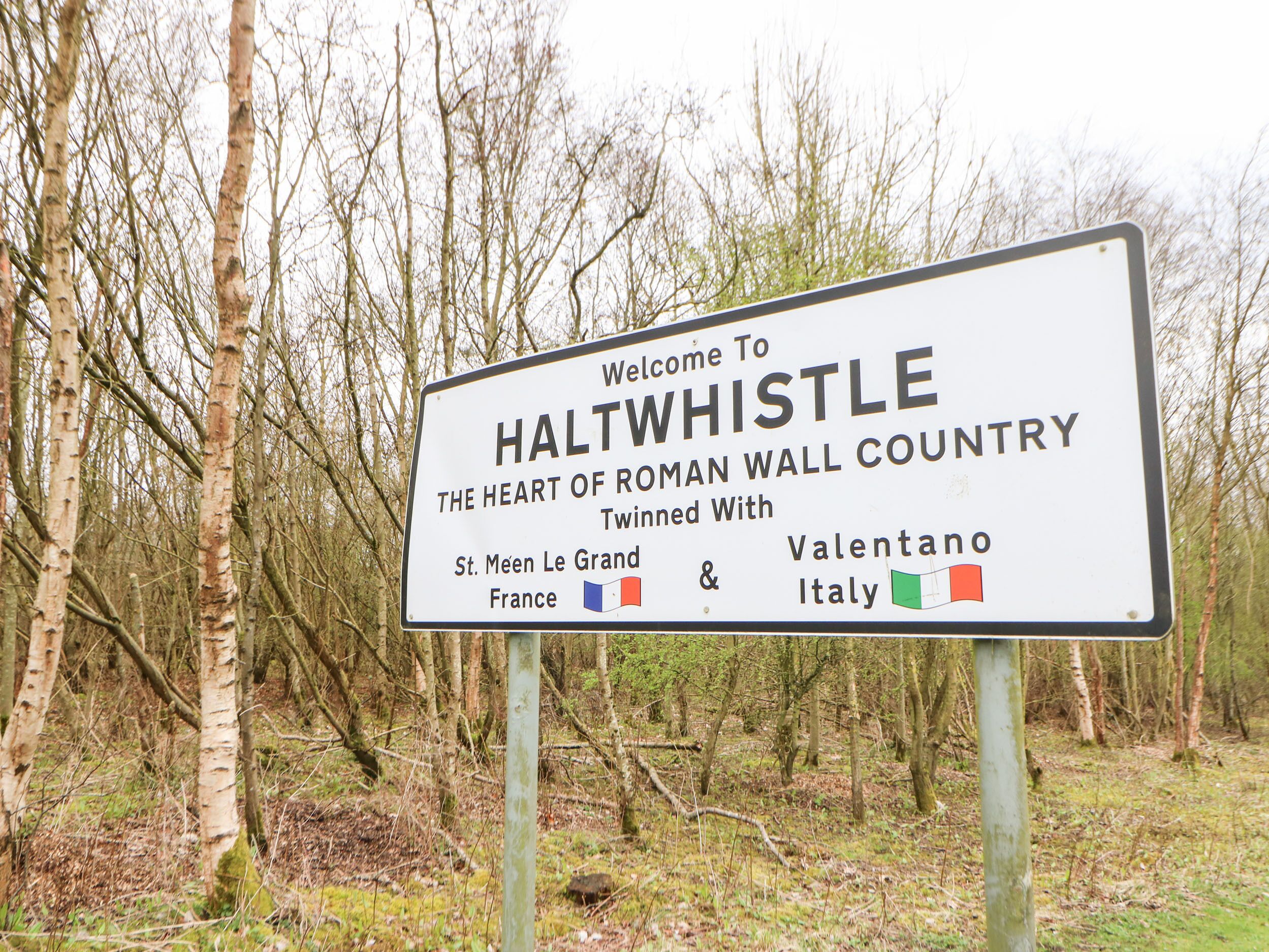 Una señal de bienvenida a Haltwhistle, que menciona sus ciudades gemelas: St. Mén-le-Grand, en Francia, y Valenton, en Italia.