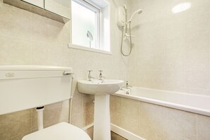 Un baño con inodoro, lavamanos y bañera.