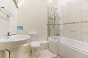 Bathroom features a sink, toilet, and bathtub with a glass-enclosed shower.