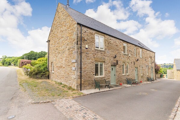 Stunning stone building with a charming entrance, complete with a green door and inviting porch.