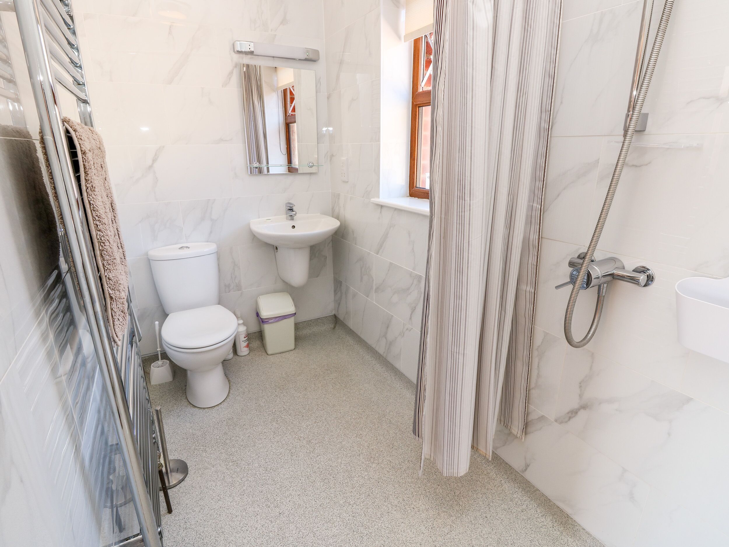 Une petite salle de bain avec des toilettes, un lavabo et une douche.