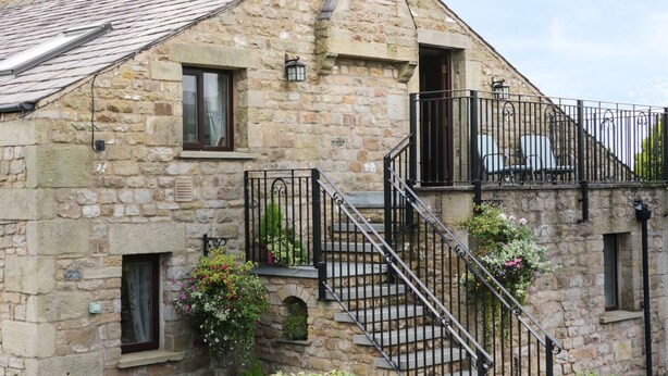 A stone building with a staircase leading to a balcony. - Hazelwood Cottage (Carnforth)