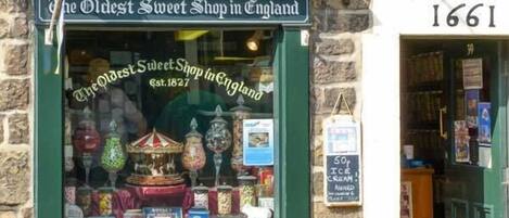 A storefront with a sign reading "The Oldest Sweet Shop in England" and a date "Est. 1827".