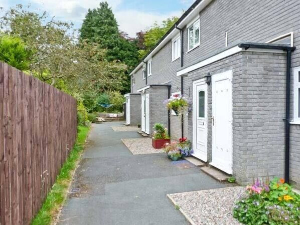 A narrow residential street with houses on either side, a wooden fence, and a pathway. - Baytree Apartment (Grange-over-Sands)
