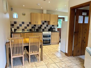 Enjoy meals in this kitchen with a dining table and oven.