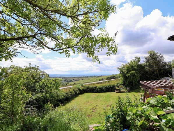 A lush garden with a view of a distant road and landscape. - Southview (Ludlow)