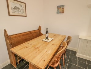 Enjoy meals in this dining area with a wooden table, comfortable chairs, and a convenient cabinet.