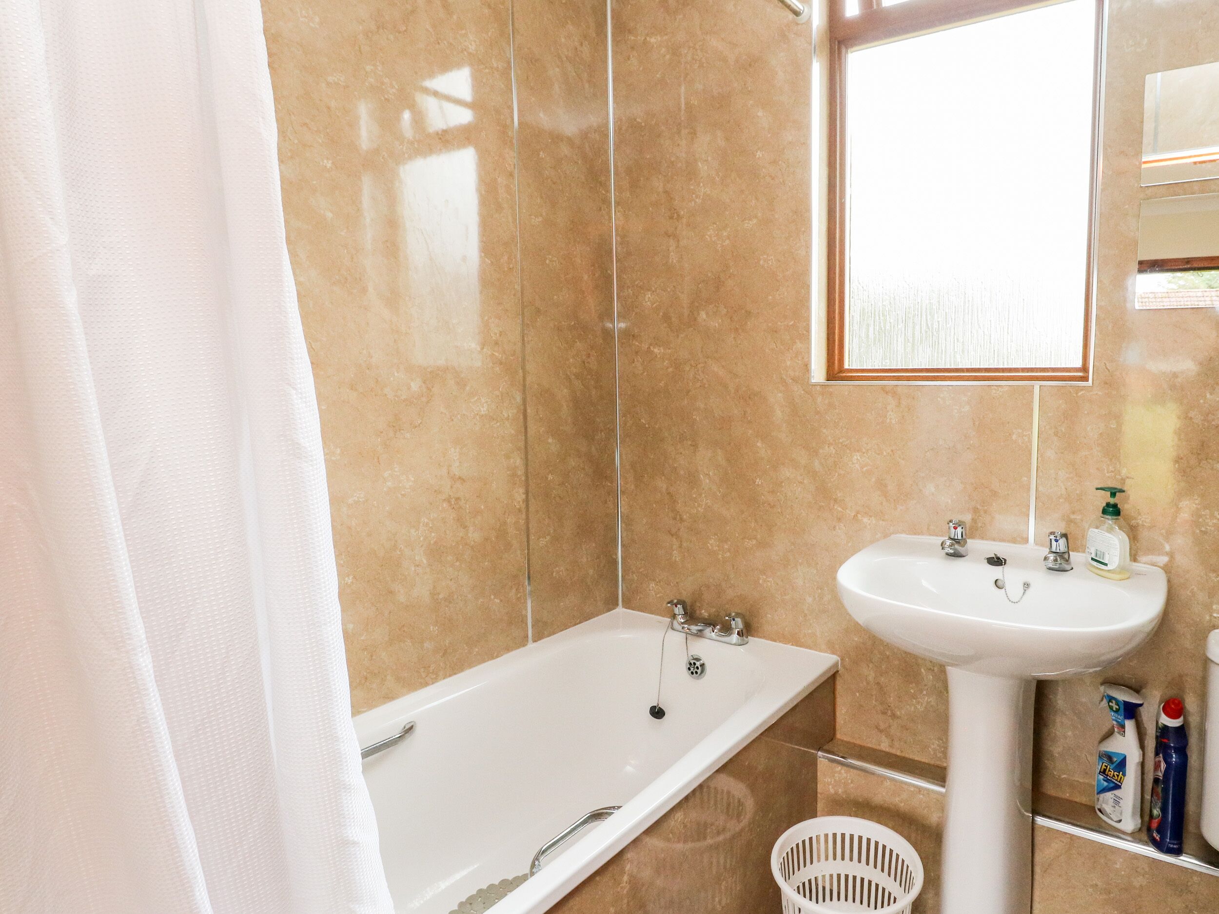 Un baño con bañera, lavabo y espejo.