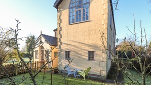 A two-story stone building with a large window and a small balcony. - Ashfield Studio (Market Rasen)