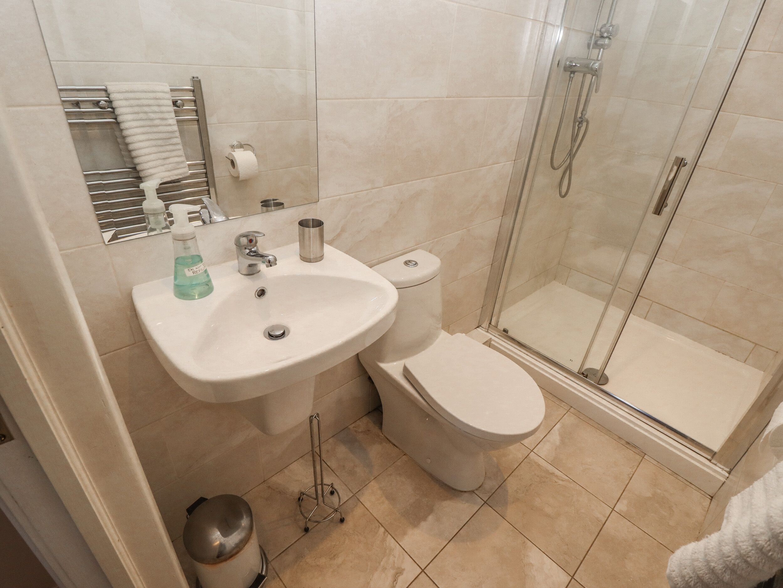A bathroom with a sink, toilet, and glass-enclosed shower.