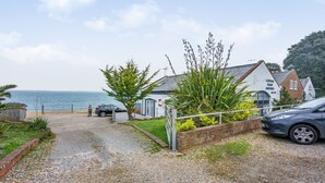 A coastal property with a gravel driveway, a gated entrance, and a view of the sea. - West Sea View No 4 (Yarmouth)