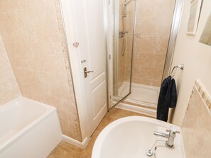 A bathroom with a bathtub, a shower enclosure, and a sink. - Driftwood Apartment (Morpeth)