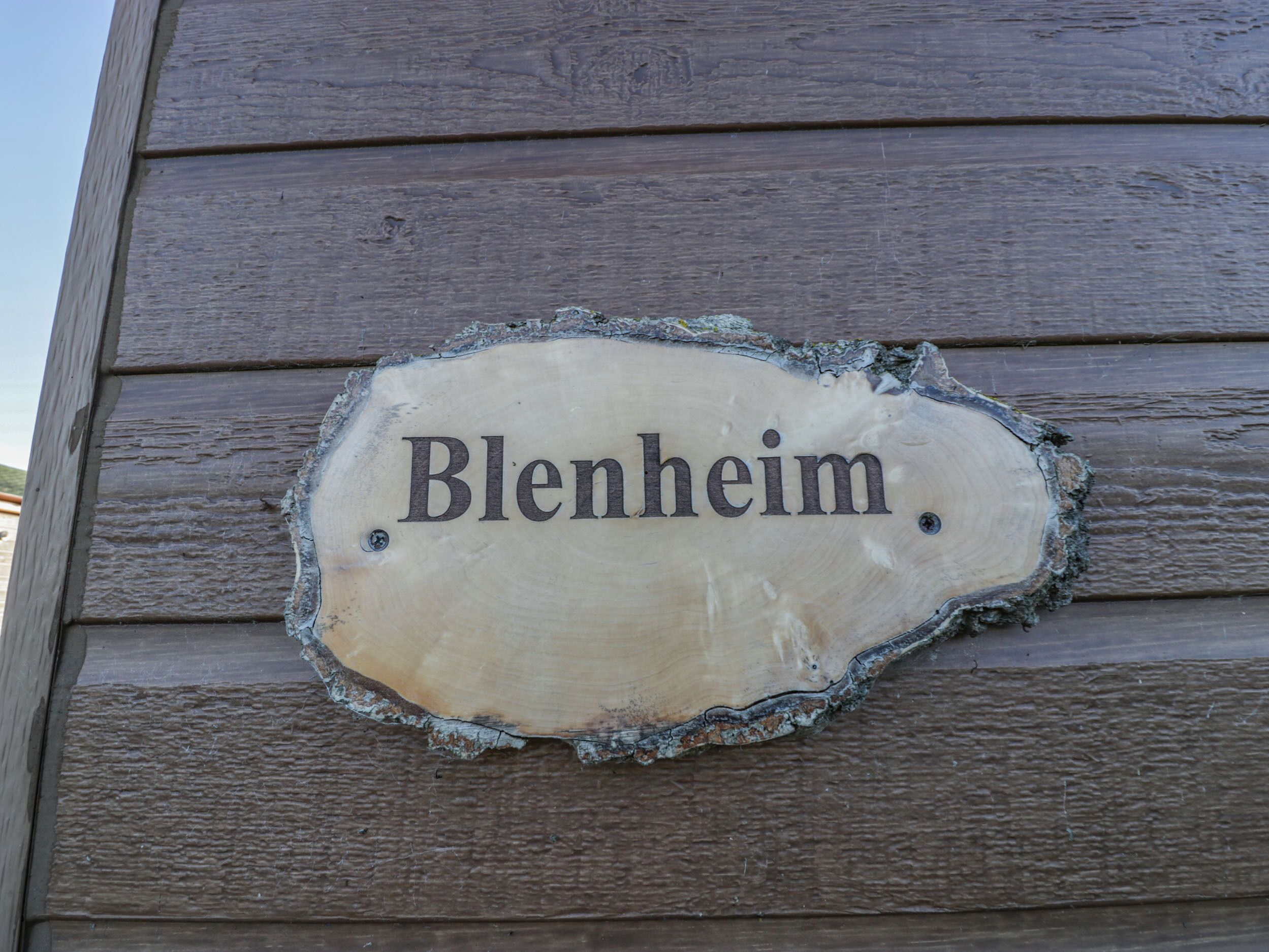 Un letrero de madera con el nombre 'Blenheim' fijado a una pared de madera.