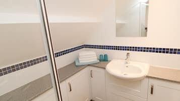 A bathroom with a sink, mirror, and cabinets.