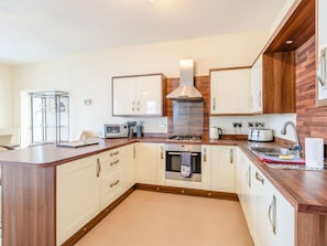 Enjoy cooking in this well-equipped kitchen with a central island, microwave, and modern appliances.