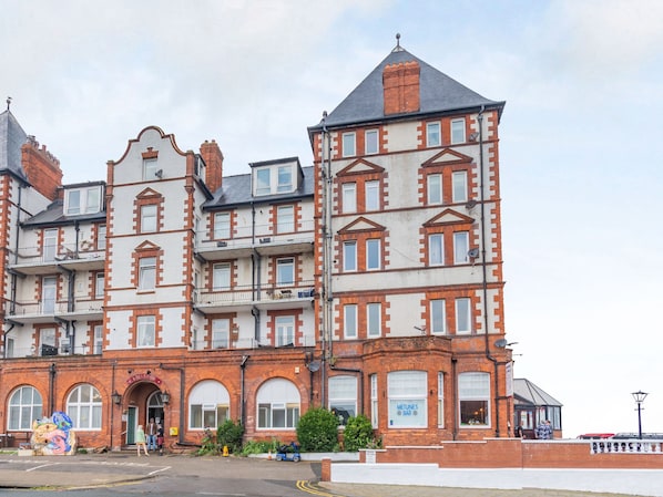 Classic building with a brick and white facade, featuring multiple windows and decorative details.