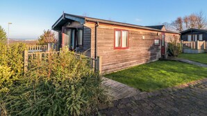A wooden mobile home with a small front porch and a grassy yard. - Hawthorne Lodge (Saltburn-by-the-Sea)