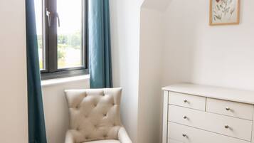 Een hoekappartement met raam, stoel en dressoir.
