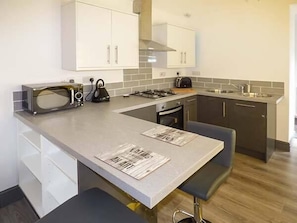 Compact kitchen with appliances, gas stove, and island workspace.
