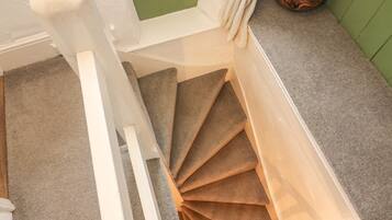 Een trap met een bekleed plateau en een groene wand.